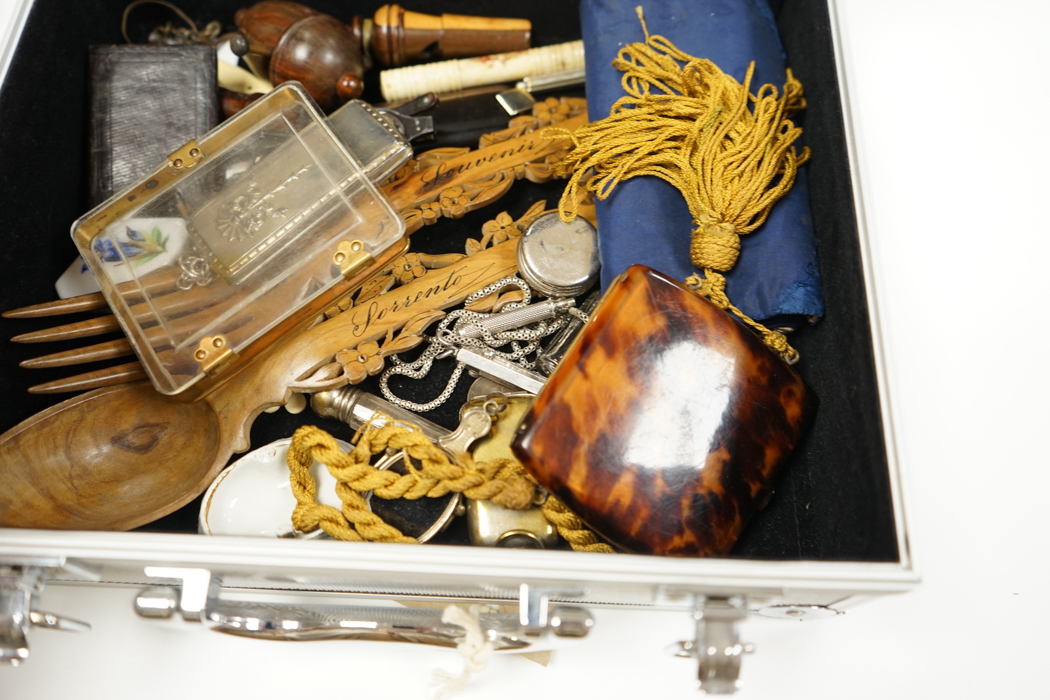 A metal case containing mixed collectibles including treen whistles, a cigarette case, three white metal propelling pencils etc